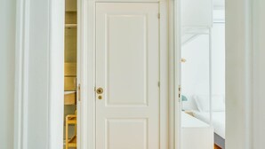 A white door leading to a bedroom with a bed and a nightstand. - GuestReady - Relaxing place in Lisbon (Lisbon)