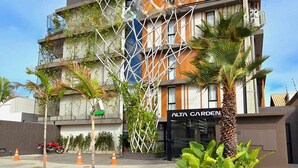 Ein mehrstöckiges Gebäude mit modernem architektonischen Design, das eine geometrische Fassade und eine Kombination aus Glas und Holz aufweist.