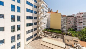 A multi-story building with a modern facade, large windows, and a rooftop terrace.