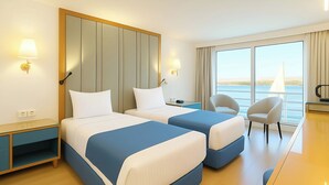 A hotel room with two beds, a desk, a chair, and a view of the sea. - Nile Cruise Royal Queen 2 Every Wednesday from Aswan 3 nights and every Saturday from Luxor 4 nights (Aswan)