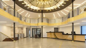 A spacious, multi-level atrium with a modern design, featuring a central staircase, a reception desk, and a large, decorative ceiling light fixture. - Nile Cruise Royal Queen 2 Every Wednesday from Aswan 3 nights and every Saturday from Luxor 4 nights (Aswan)