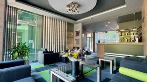 A modern lobby with a reception desk, seating area, and a bar. - Expo Hotel (Plovdiv)