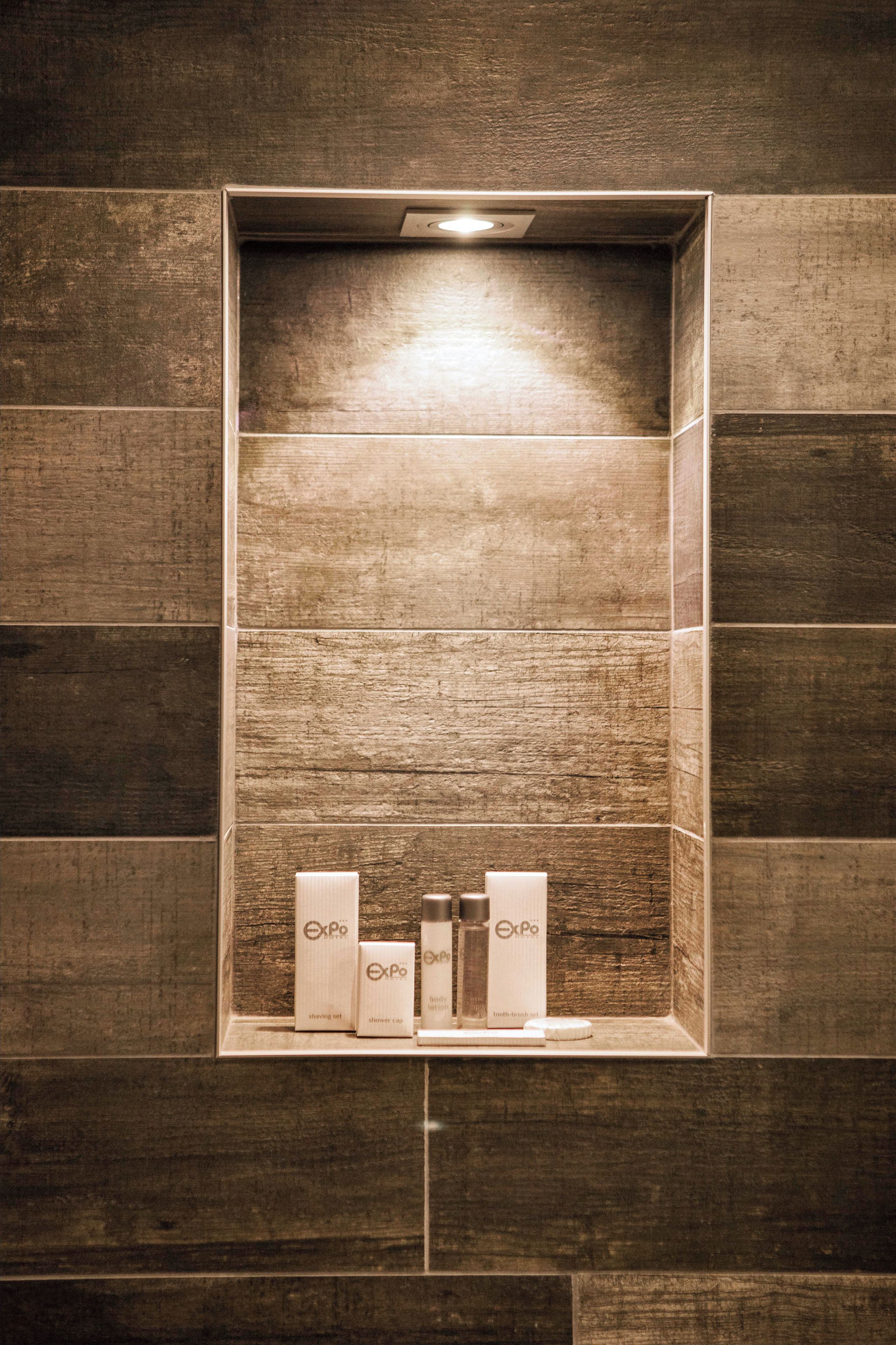 Un baño con pared de madera y repisas con artículos de aseo.