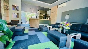 A modern lobby with a bar area, seating arrangements, and a large window providing natural light. - Expo Hotel (Plovdiv)