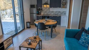 Een moderne keuken met een eetgedeelte, een blauwe bank en een tafel met een lamp.
