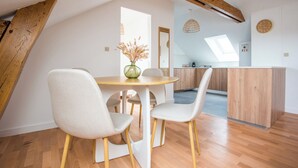 A dining area with a round table, two chairs, and a vase of dried flowers. - Cosy apartment in the heart of Angers (Angers)