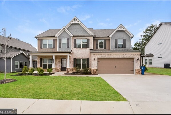 A two-story house with a garage, a front porch, and a well-maintained lawn. - Casa Aluna, World Cup FIFA Retreat Sleeps 10 (Dacula)