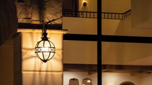Une fontaine avec des jets d’eau, un luminaire suspendu et un mur en pierre.