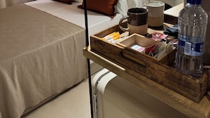 A hotel room with a bed, bedside table, and a tray with toiletries. - BELLADORA HOTEL BOUTIQUE (Lloret de Mar)