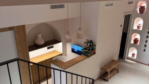 A modern interior with a staircase, a kitchen area with a wooden countertop, hanging pendant lights, and a wall with ceramic pots. - BELLADORA HOTEL BOUTIQUE (Lloret de Mar)