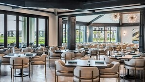 Un comedor espacioso con techos altos y ventanas amplias que ofrecen vistas al exterior.
