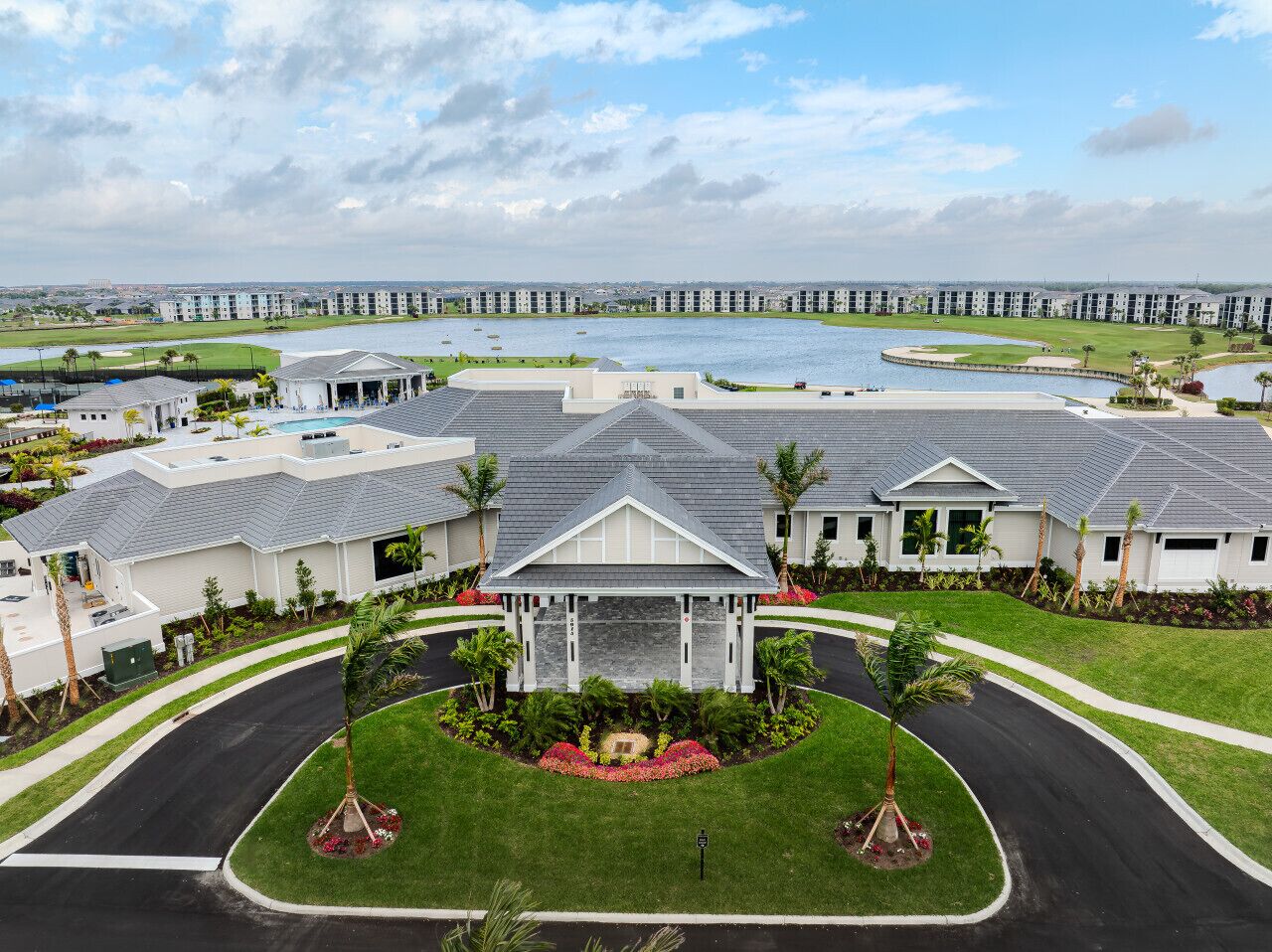 Um hotel moderno com um pátio central, rodeado por uma piscina e um campo de golfe.