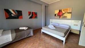 Una habitación de hotel con dos camas, un ventanal grande y obras de arte en las paredes.