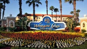 Señal de Westgate Lakes Resort & Spa rodeada de palmeras y un jardín ajardinado.