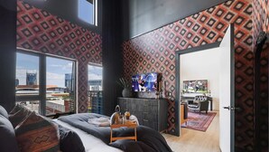 A modern hotel room with a large bed, a TV, and a city view. - Skyline Views from Nashville Penthouse – Pool & Minutes to Broadway (Nashville)