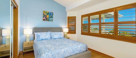 A bedroom with a bed, nightstands, a ceiling fan, and a window with blinds.