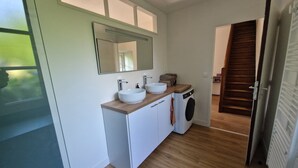 A modern bathroom with a double sink, a mirror, and a washing machine. - Gîte du Château de la Haye, I History and Nature (Saint-Hilaire-des-Landes)
