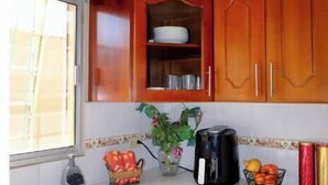 A kitchen with wooden cabinets, a sink, and various kitchen items on the countertop.