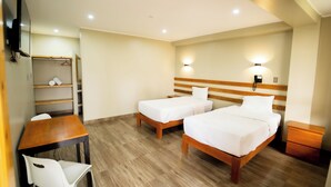 A hotel room with two beds, a wooden desk, a chair, a wardrobe, and a bedside table. - Fundo San Rafael (Nazca)