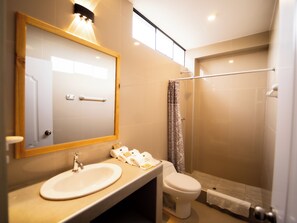 Un bagno moderno con lavandino, WC e doccia.