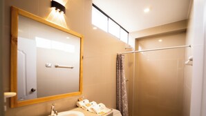 A modern bathroom with a sink, toilet, and shower. - Fundo San Rafael (Nazca)