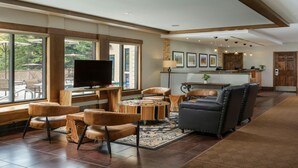 A spacious living area with a flat-screen TV, leather sofas, and a dining table.