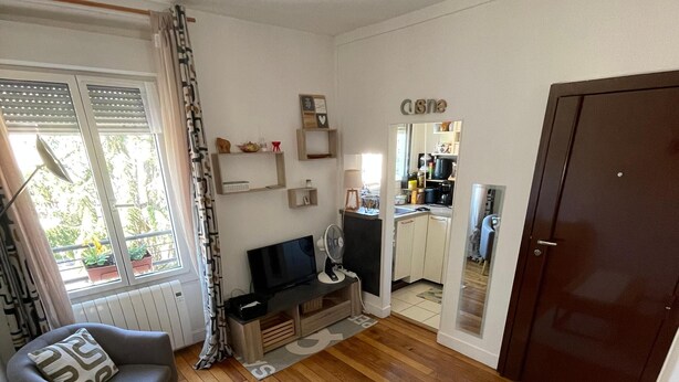 A living room with a sofa, a TV, a wooden coffee table, and a kitchen in the background. - Nice 2 rooms, cosy, quiet - Near forest - Near Paris ! (Sèvres)