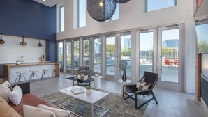 A spacious living area with a kitchen, large windows, and a view of the city.