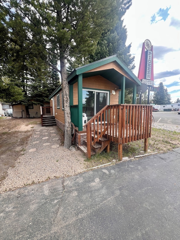 Ein kleines Motel mit Holzfassade, einer Veranda und einer Treppe, die zum Eingang führt.