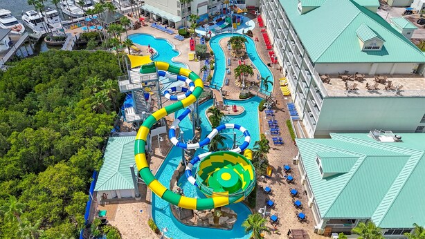 Ein Luftbild eines Resorts mit mehreren Schwimmbecken, Wasserrutschen und einem großen Wasserpark im Zentrum.