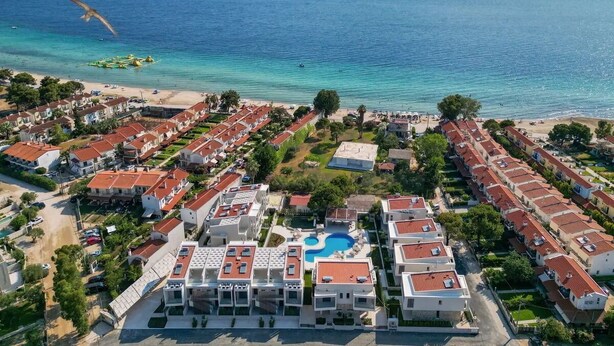 A coastal resort with multiple buildings, a swimming pool, and a beach. - Darion Townhouse (Nikiti)