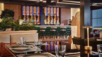 A modern bar area with neatly arranged seating and a variety of liquor bottles.