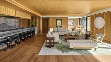 A modern living room with a bar area, wooden flooring, and a large abstract painting on the wall.
