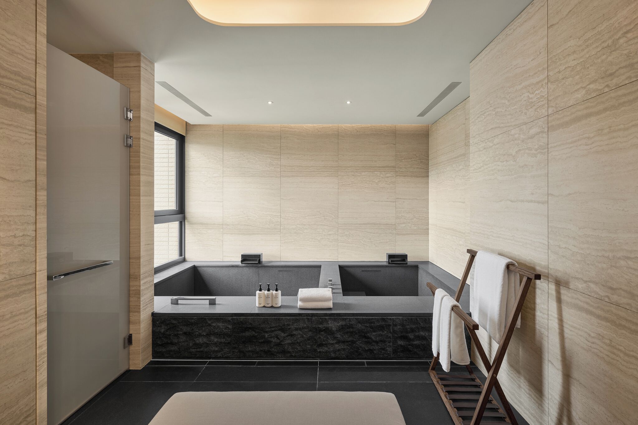 Une salle de bain moderne avec une grande baignoire, un meuble-lavabo avec un miroir et un porte-serviettes.