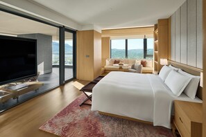 A modern hotel room with a large bed, a flat-screen TV, a sofa, and a balcony with a city view. - Intercontinental New Taipei Hot Spring by IHG (New Taipei City)