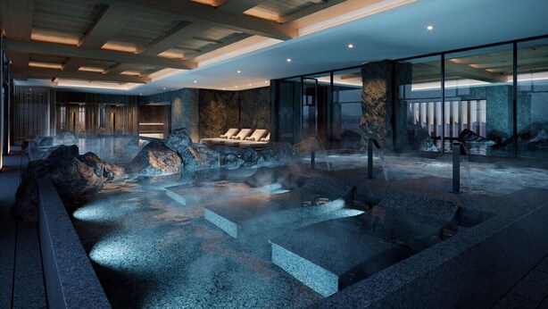 Un espace spa moderne doté d’une source d’eau chaude, de sièges et d’un mur en pierre.