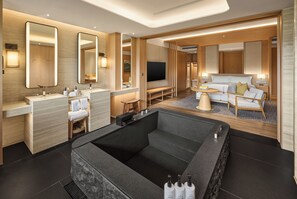Een moderne hotelkamer met een groot ligbad, een bank en een televisie.