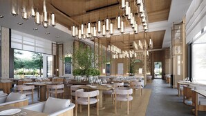 A spacious restaurant with high ceilings, hanging pendant lights, and a large indoor plant. Tables are set with white tablecloths and chairs. - Intercontinental New Taipei Hot Spring by IHG (New Taipei City)