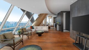A modern living room with a city view, a dining area, and a large flat-screen TV. - Holiday Inn Xingtai Quancheng by IHG (Xingtai)