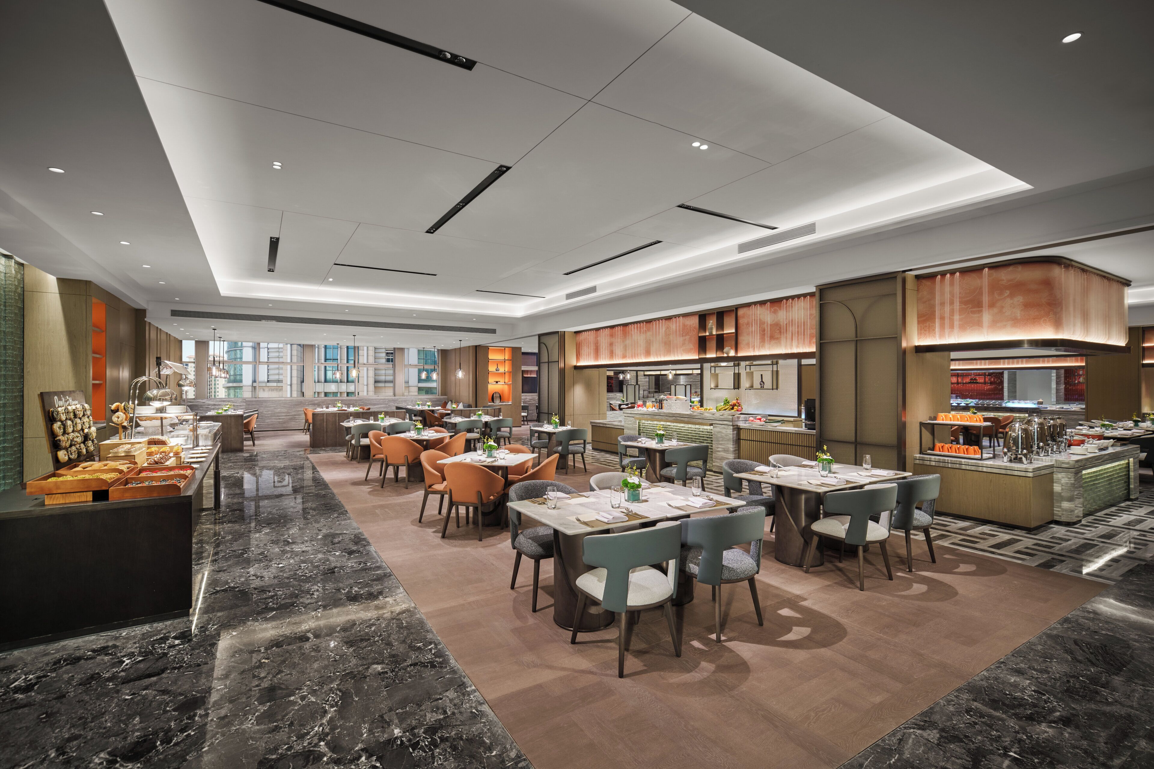 A spacious restaurant with marble flooring, multiple dining areas, and a central kitchen.