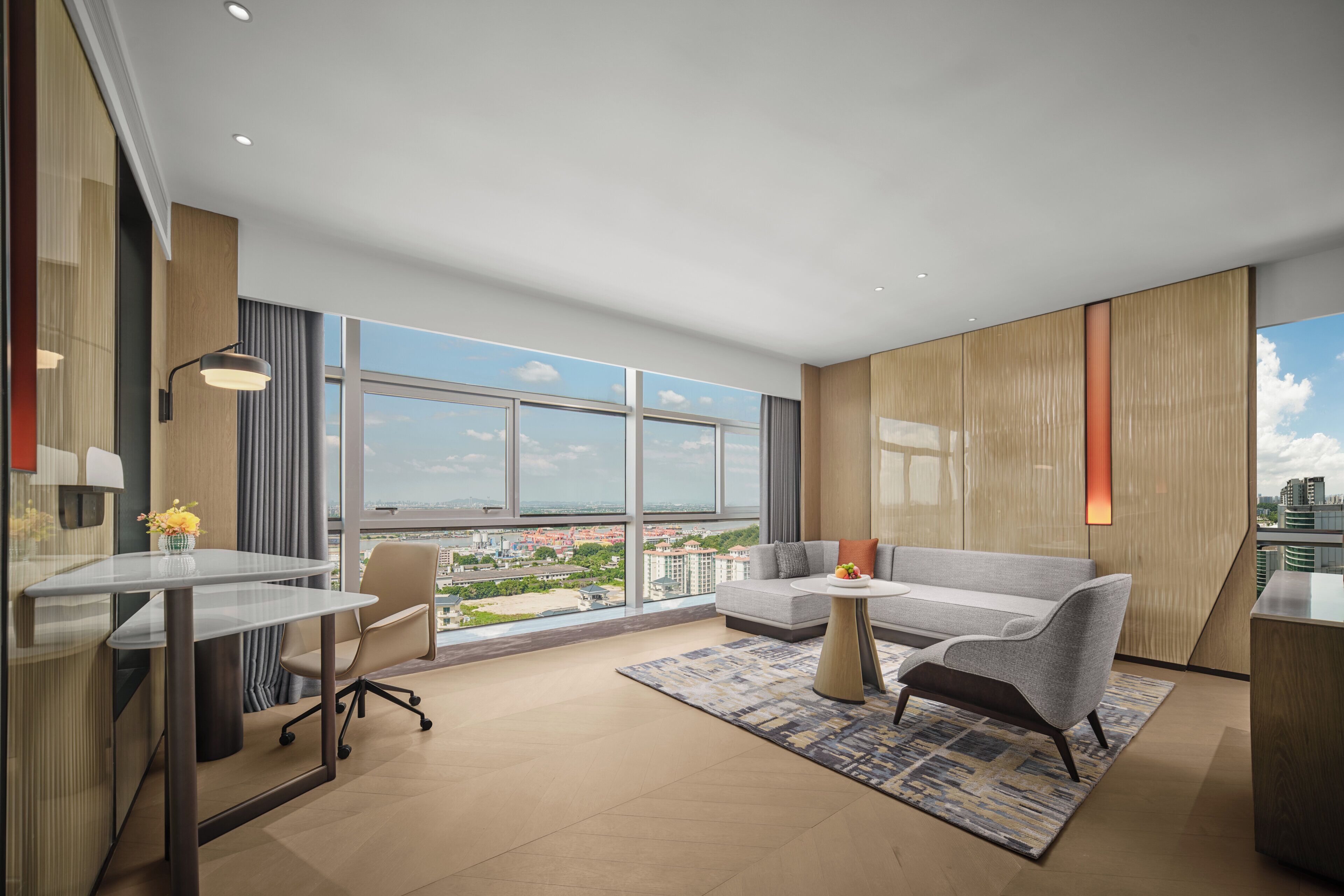 Una sala moderna con una mesa de vidrio, un sofá y vista a la ciudad.