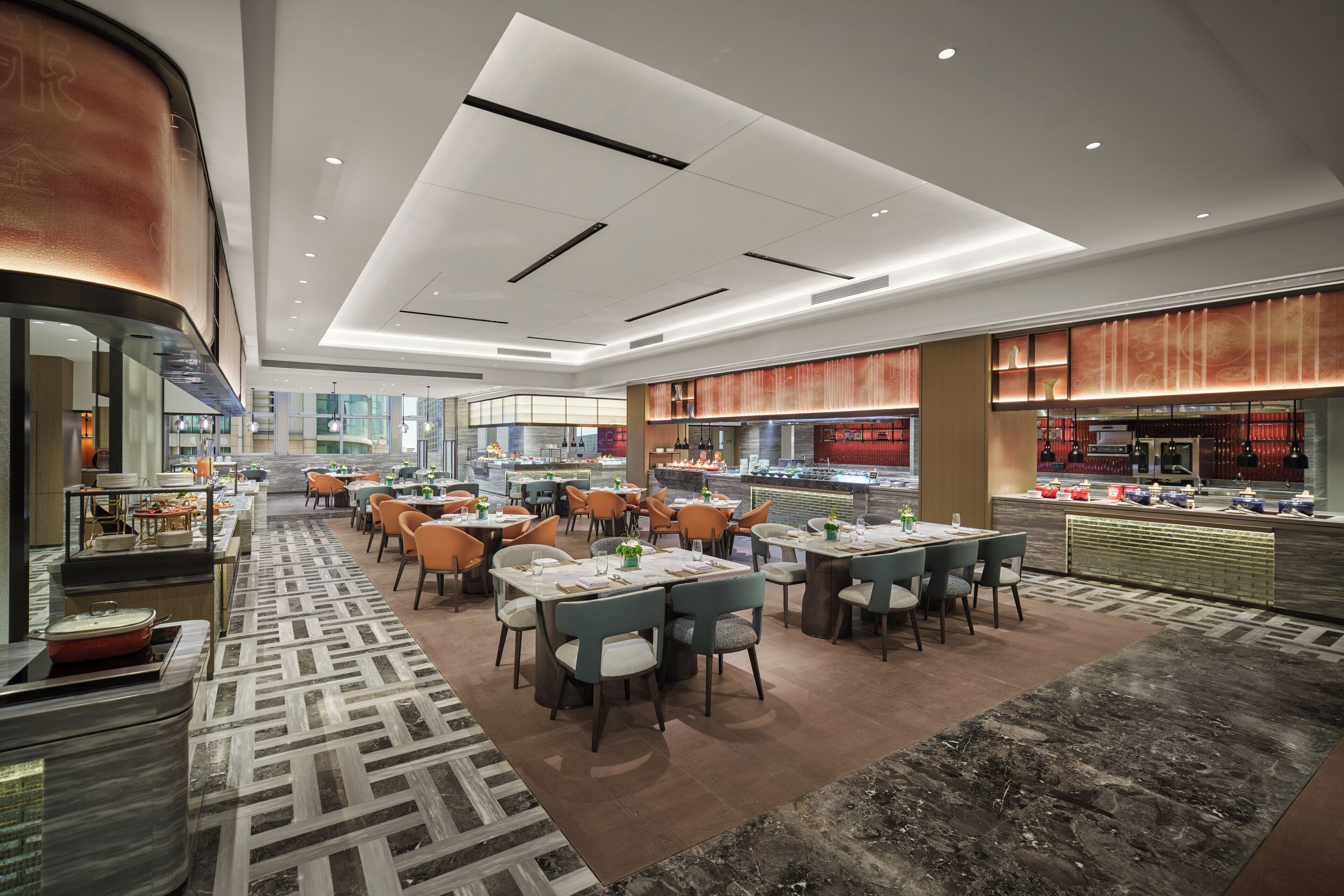 A spacious restaurant with multiple dining tables and chairs, a central bar area, and a patterned floor.