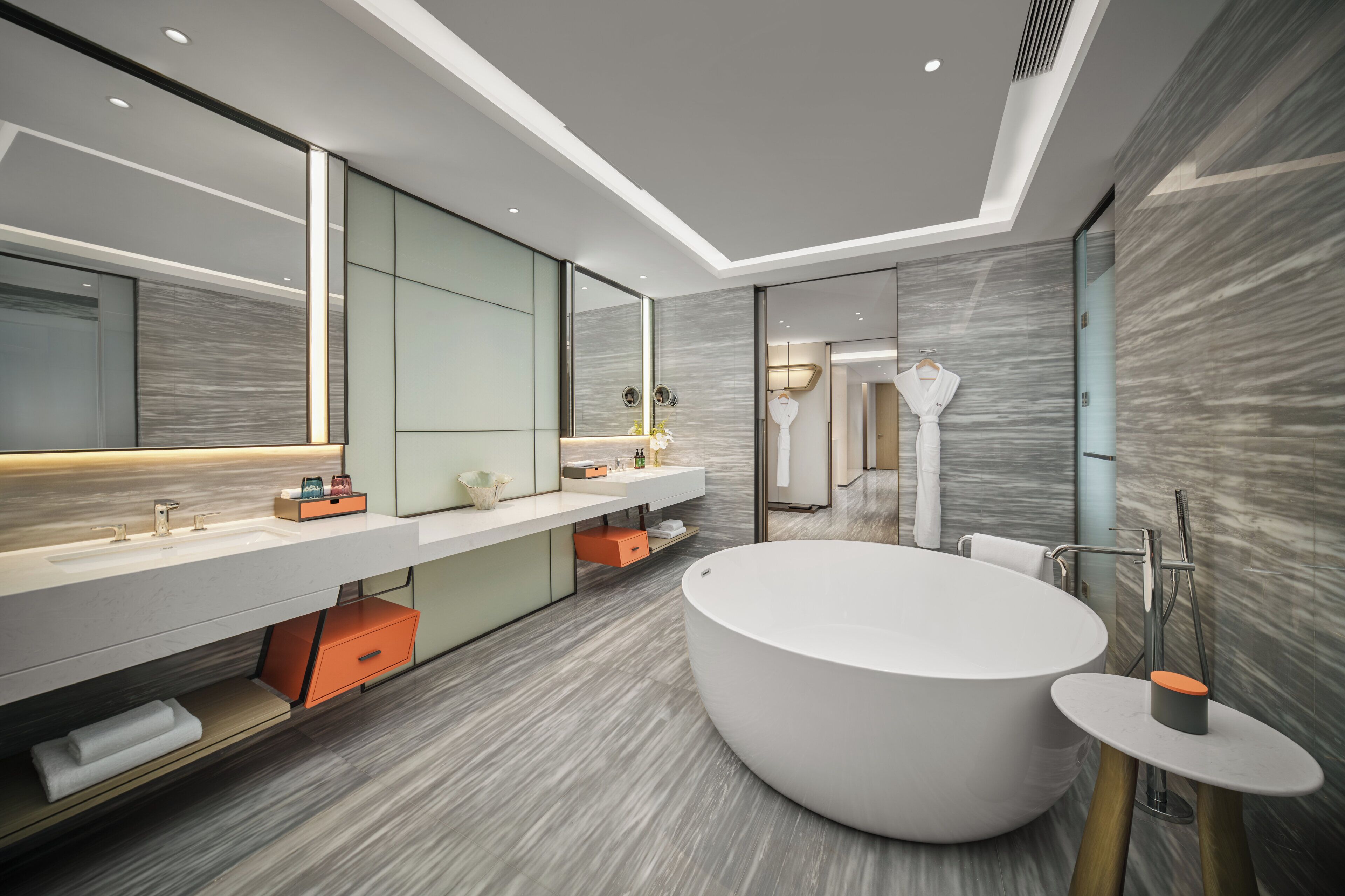 Une salle de bain moderne avec une grande baignoire, un meuble-lavabo avec un miroir et un porte-serviettes.
