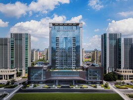 Un edificio moderno con fachada de vidrio y el nombre 'CROWNE PLAZA' en la parte superior.
