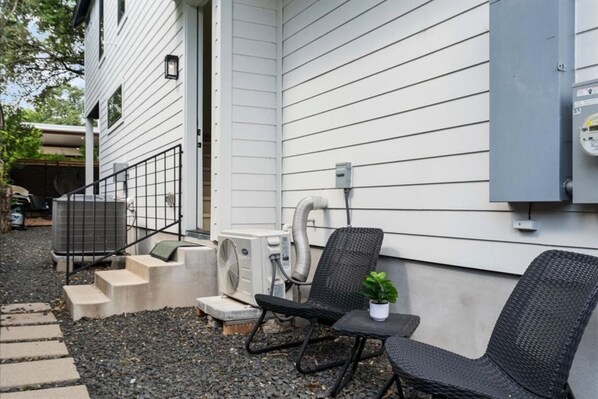 A patio with outdoor furniture, a small table, and a potted plant.
