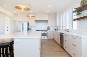 Coffee/tea maker, paper towels, dining tables, kitchen islands