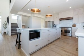 Coffee/tea maker, paper towels, dining tables, kitchen islands