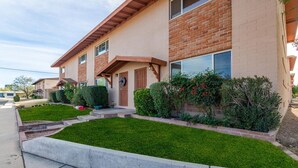 A two-story residential building with a brick facade, a front porch, and a well-maintained lawn. - Sweet home nearby UOA (Tucson)