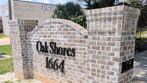 A brick wall with the text "Oak Shores 1664" indicating a location or address.