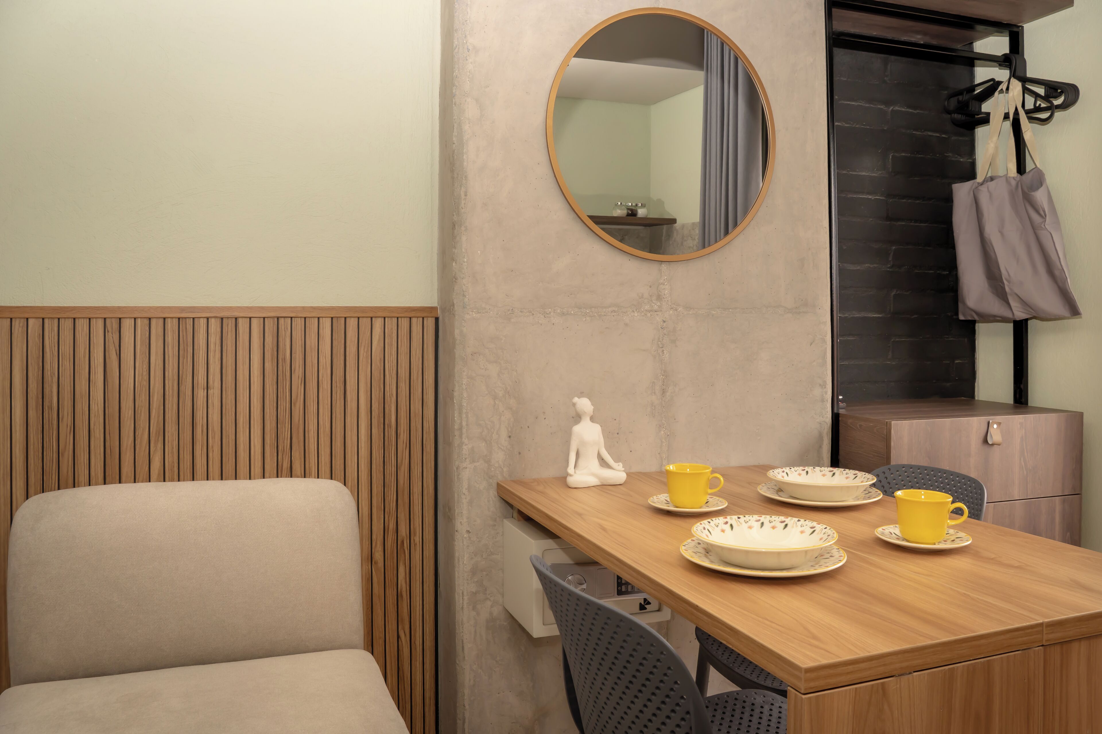 Une pièce comprenant une table à manger en bois, une chaise, un miroir et un meuble.